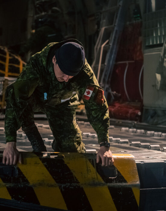 A Traffic Technician with Air Task-Force Prestwick prepares to unload aircraft cargo pallets from a CC-130J Hercules