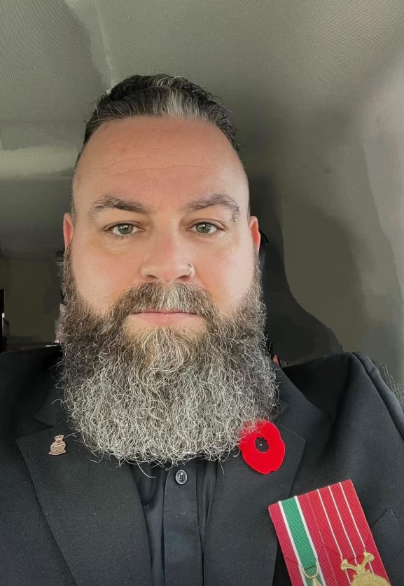 Cory Pike, member of the Veterans Wellness Alliance, dressed in uniform posing for the camera