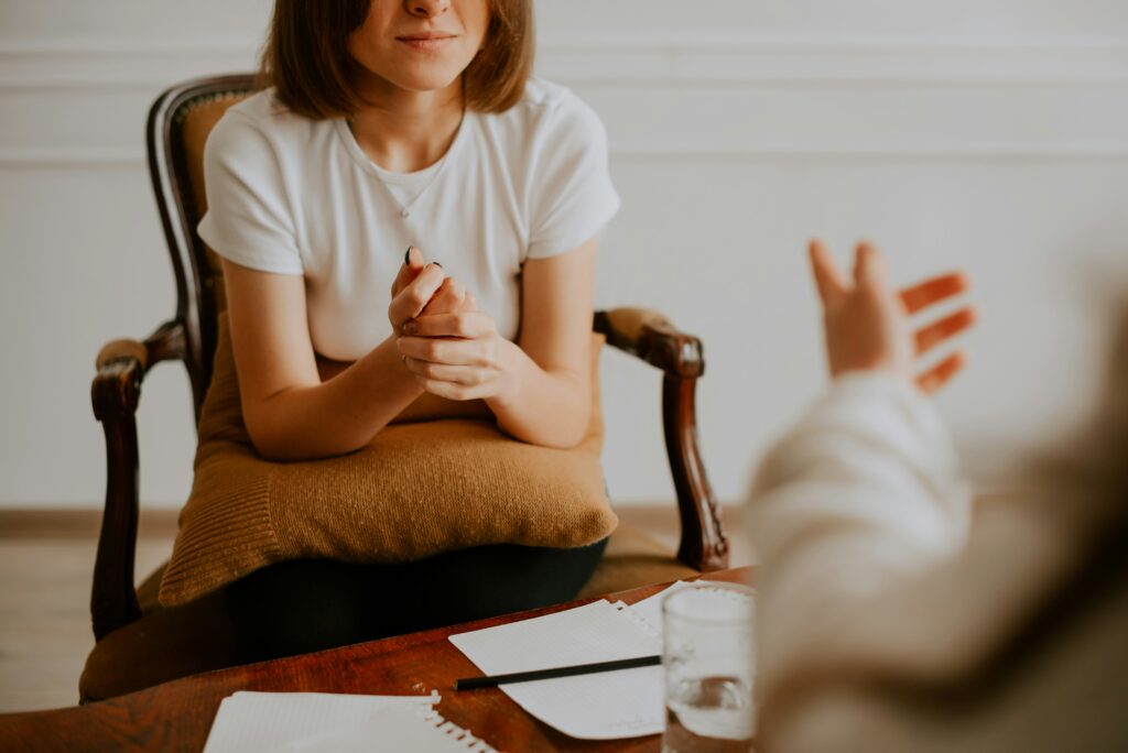 A woman is seated in a therapy session